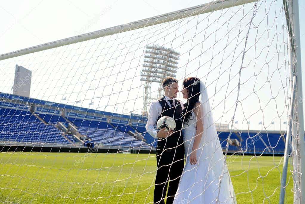 depositphotos_104840306-stock-photo-wedding-couple-on-football-stadium